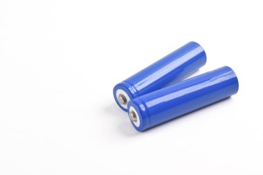 Beyaz arka planda iki mavi AA büyüklüğünde pil izole edilmiş.