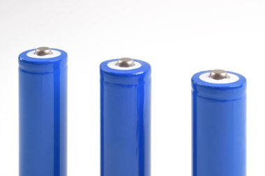 Mavi metal AA büyüklüğünde bataryalar beyaz arka planda izole edilmiş. Karbon çinko piller, şarj edilebilir piller, model.