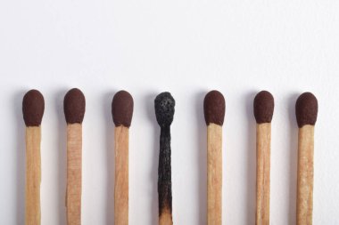 Beyaz arkaplanda yanmış eşleşmeler var. Yanan kibritlerin farklı aşamaları.