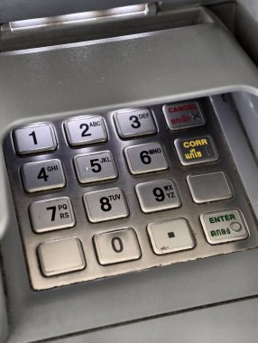Detailed view of a metallic ATM keypad, showing numbers and function keys.