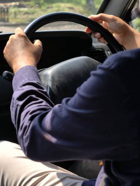 Araba kullanırken direksiyonda bulunan bir kişinin yakın plan fotoğrafı..