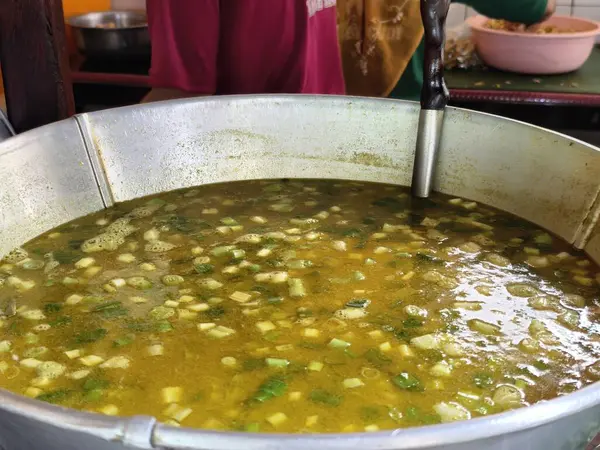 Sıcak soto çorbasıyla dolu büyük metal bir tencereye yakın çekim, servis edilmeye hazır..