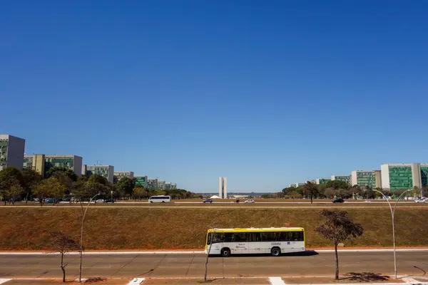 stock image public bus crossing the Esplanade of Ministries avenue with Federal congress as backdrop. Brasilia, Brazil.