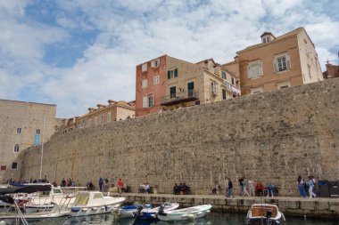 Dubrovnik, Hırvatistan - 04.26.2025: Porat Dubrovnik limanında taş duvarların yanındaki gemiler ve motorbotlar.
