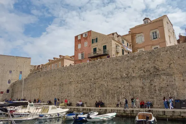 Dubrovnik, Hırvatistan - 04.26.2025: Porat Dubrovnik limanında taş duvarların yanındaki gemiler ve motorbotlar.