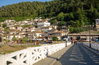 Berat, Arnavutluk - 05.18.2025: Osum Nehri üzerindeki eski Gorica köprüsü. Arkaplan olarak şehir manzarası.