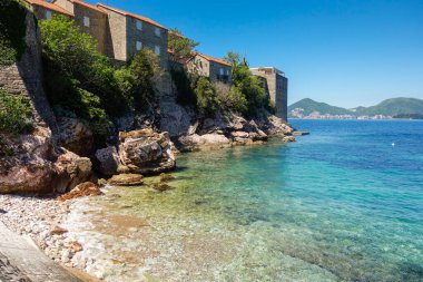 Budva Riviera 'daki muhteşem Sveti Stefan plajı. Güneşli bir günde berrak sular.