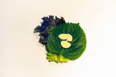 Sliced garlic on the fresh sesame leaf and lettuce