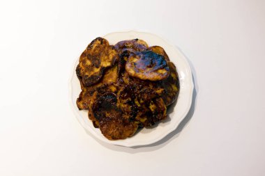 A pile of Korean hotteok that a bit burnt on the white plate