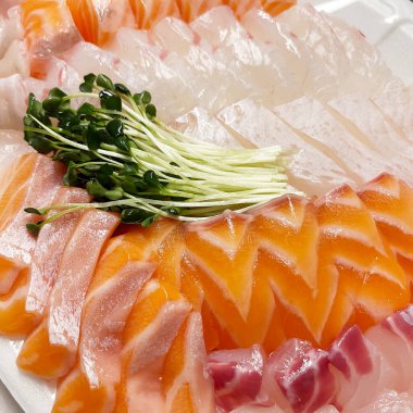 A plate of various raw fish with salmon, halibut and radish sprouts in South Korea