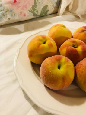 Lovely peaches are on the white dish