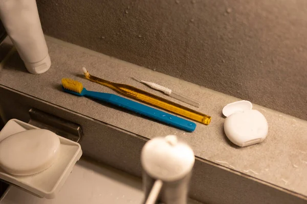 Various toothbrushes with dental floss in the bathroom
