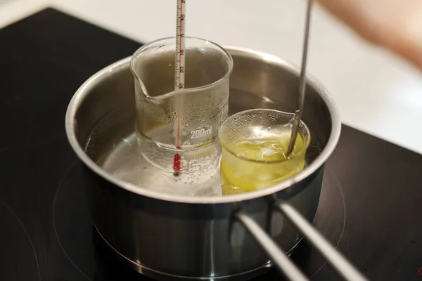 Heat beakers of water and jojoba oil in boiling water, record the temperature with a thermometer
