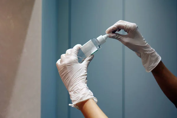 Gloved hands holding the liquid bottle in the laboratory