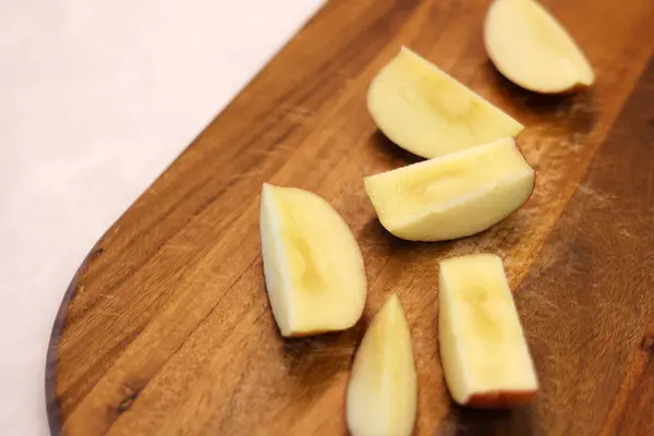 Sliced of apples on the wooden cutting board