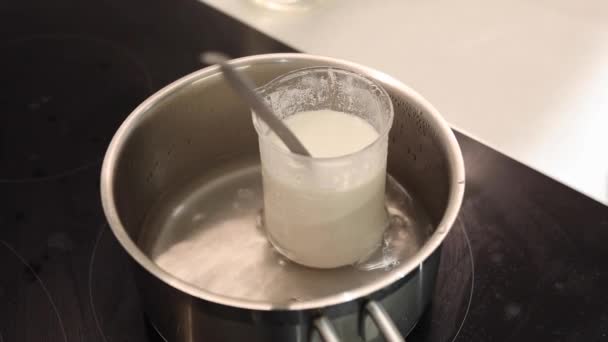 水和荷荷巴油在沸水中的热烧杯 — 图库视频影像