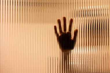 One hand on the textured glass