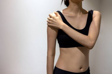 Woman puts her hand on shoulder in black sportswear