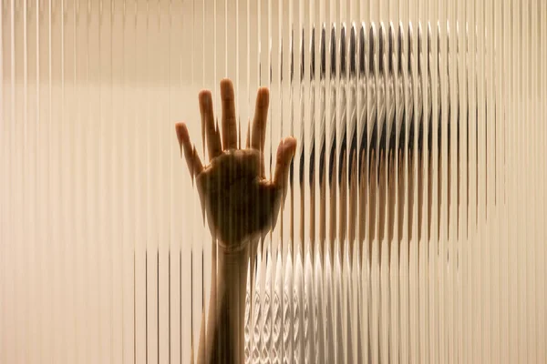 One hand on the textured glass