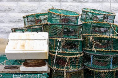 Balık ağları ve balıkçılık araçlarıyla dolu bir liman kasabası.