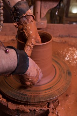 Potter's hand making a vessel