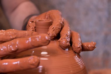 Potter's hand making a vessel