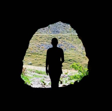 silhouette of a hiker girl in a natural grotto. High quality photo