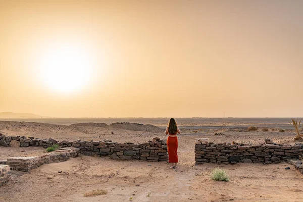 woman watching the sunrise in the desert of Morocco. High quality photo