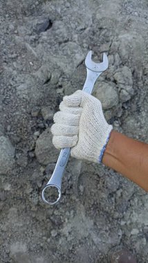 worker's hand holding work tool