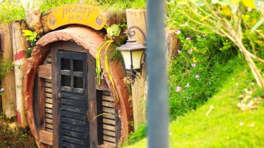Small house in the garden with vintage lanterns and flowers.