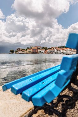 Kefalonya 'nın İyon Adası' ndaki Fiskardo köyü Yunanistan, yaz tatili beldesi, bulutlu gökyüzü ve güzel manzara, mavi bank.