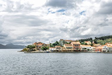 Kefalonya 'nın İyon Adası' ndaki Fiskardo köyü Yunanistan, yaz tatili beldesi, bulutlu gökyüzü ve güzel manzara.