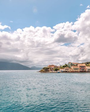 Kefalonya 'nın İyon Adası' ndaki Fiskardo köyü Yunanistan, yaz tatili beldesi, bulutlu gökyüzü ve güzel manzara.