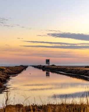 Yunanistan Dedeağaç yakınlarındaki Evros Deltası Ulusal Parkı 'nda gün batımı veya gün doğumu, kuş gözlemevi yansıması.