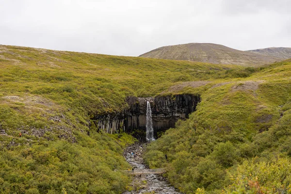 Icelandic landscape with waterfall in the centre
