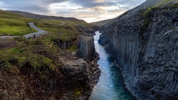 a narrow body of water with a mountain in the background