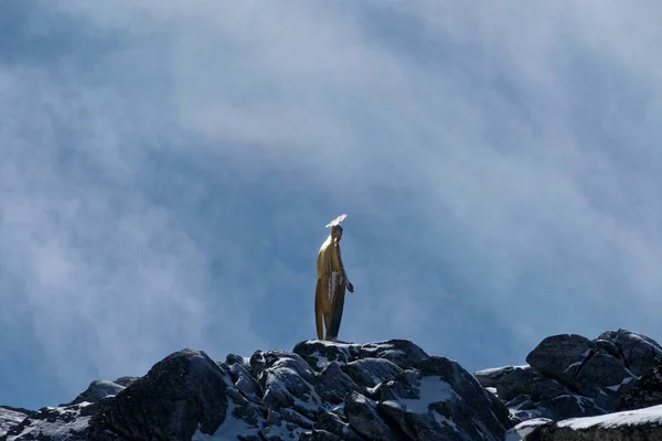 a man sitting on a rock and looking for the camera