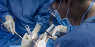 Team of doctor perform total knee replacement surgery in osteoarthritis patient inside the operating room. Selective focus at oscillating saw thar cutting the bone.Close up photo.Medical concept.