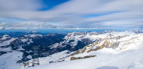 Panorama winter landscape of mountains in Switzerland.Snow mountain with a ski slope in the winter season.Summit of Titlis mountain with snow coverage on a sunny day.