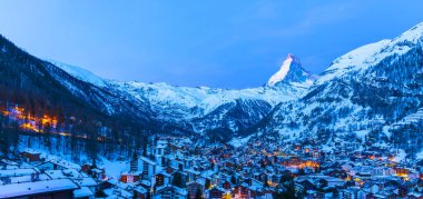 Panorama landscape of Matterhorn summit in winter morning before sunrise.Twilight sunset and light form Zermatt city.Aerial cityscape of  Zermatt,Switzerland.Blue sky and snow mountain with ski resort