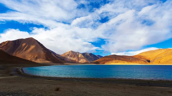 Panorama landscape of Pangong lake with mountain background under winter blue sky.Pangong tso with cloudy sky.Natural beauty of Ladakh,India. Famous tourist place in the world.China and India border.