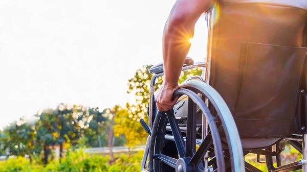 장애인 공원에서 조명을 받으며 휠체어에 바퀴를 정형외과 문제가 노인을 휠체어에 — 스톡 사진
