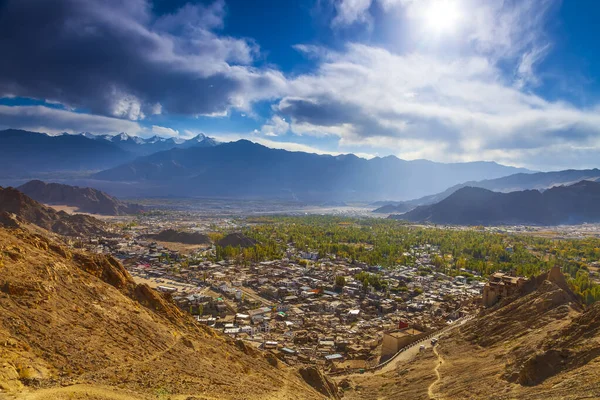 Panorama landscape of Ladakh city,India.Beautiful view from peak of Leh palace at sunset time.Winter blue sky with cloud and lens flare.Cityscape of vintage town in north India.Mountain on background.