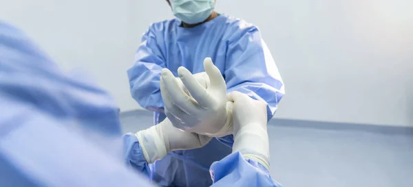 Nővér Tesz Egy Sebészeti Kesztyű Sebész Kezét Emberek Kék Egyenruhában — Stock Fotó