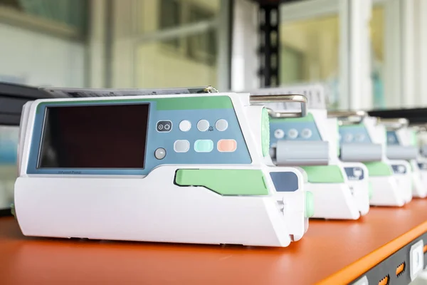 Many of medical infusion pump in medical equipment or device unit that prepare and calibrate for patient in hospital. White tool with screen monitor with blur background.Instrument use in ICU.