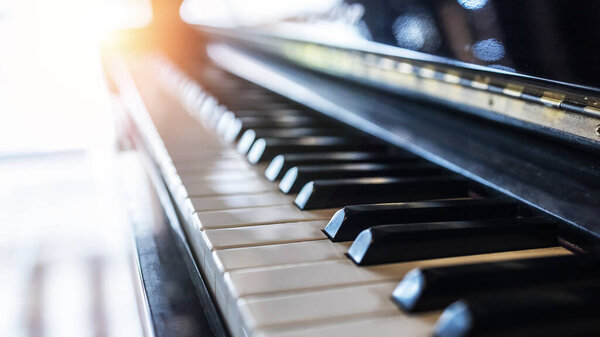 Клавиатура фортепиано под углом наклона с выборочной фокусировкой. Теплый цвет тонированное изображение с оранжевым светом Efft.Blur фона с space.Black и белый рояль..
