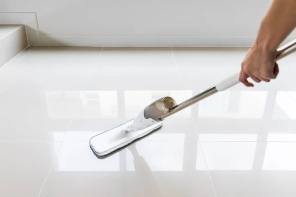 Temizlikçi paspas tutuyor. Ev hanımı yerleri temizliyor. Paspas tutan kadına yakın. Evini siliyor..