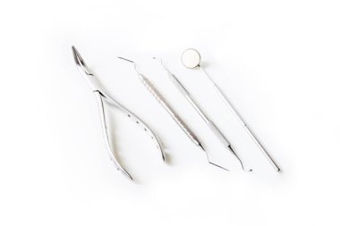 Hastanedeki diş sağlığı kliniğinde beyaz arka planda izole edilmiş diş aleti veya ekipmanların kapatılması. Diş macunu aynası, Gigival ayırıcı ve diş ağrısı veya ortodontik sonda..