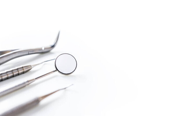 Close up of dental instrument or equipment isolated on white clean blur background inside dental clinic in hospital.Dental mouth mirror,Gigival separator and probe for toothache or Orthodontic.