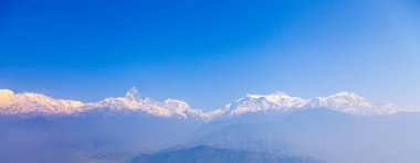 Nepal, Pokhara yakınlarındaki Sarangkot tepesinden Himalayalar 'ın panoramik manzarası. Nepal' in kış mavisi gökyüzü ile renkli manzarası. Panoramada alanı olan bir dağ. Nepal 'de parlak mavi gökyüzü ve karlı..